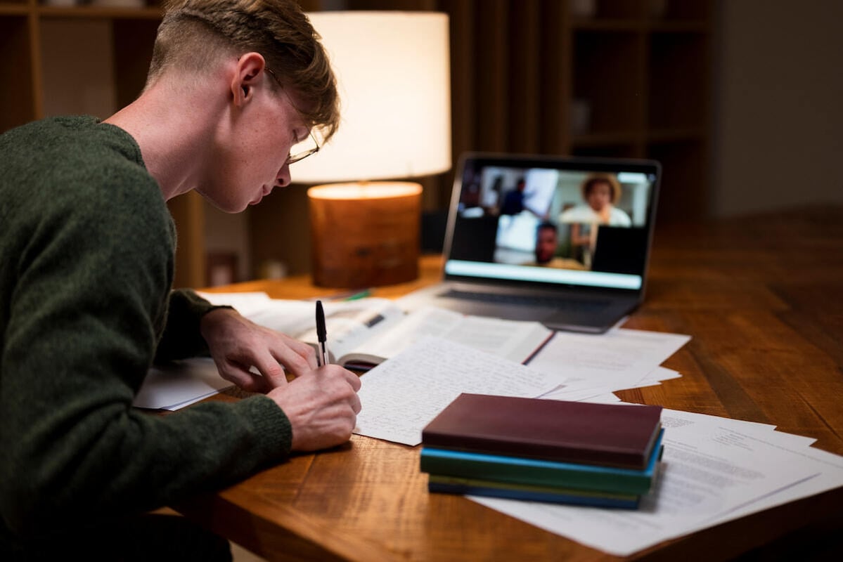 joven estudiando en su cuarto frente a su computadora